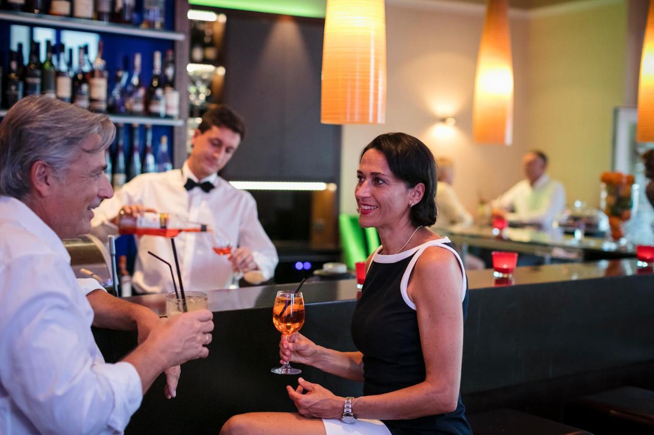 Hotel Bayerischer Hof 린다우 외부 사진 A woman drinking a cocktail